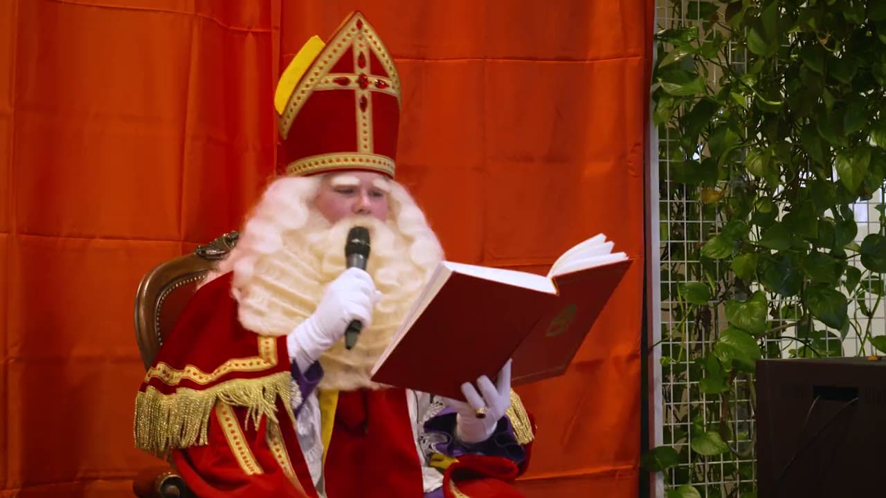 Sinterklaas leest tijdens een bedrijfsfeest voor uit het Grote Boek