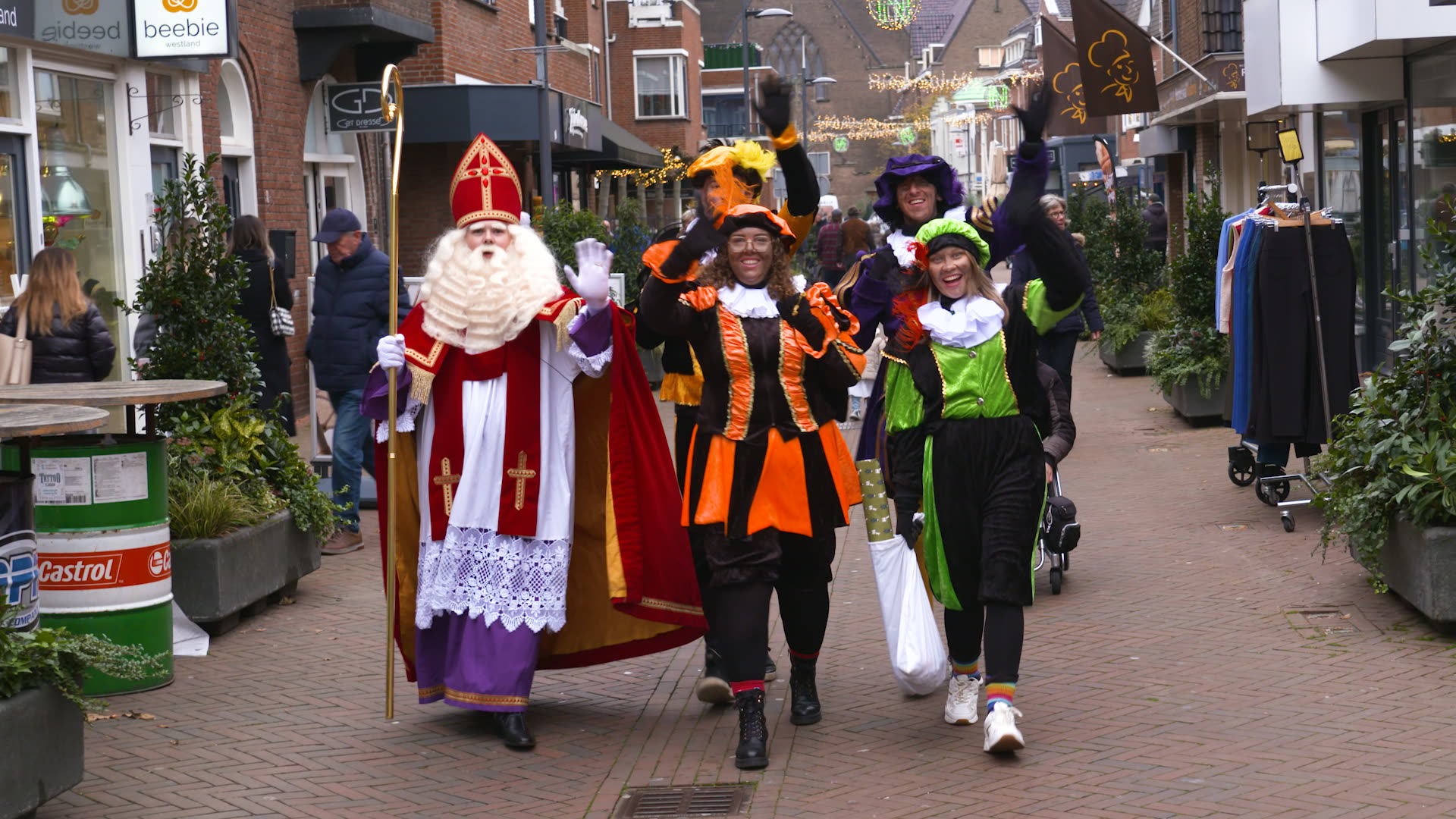 Sint en Pieten lopen door winkelstraat